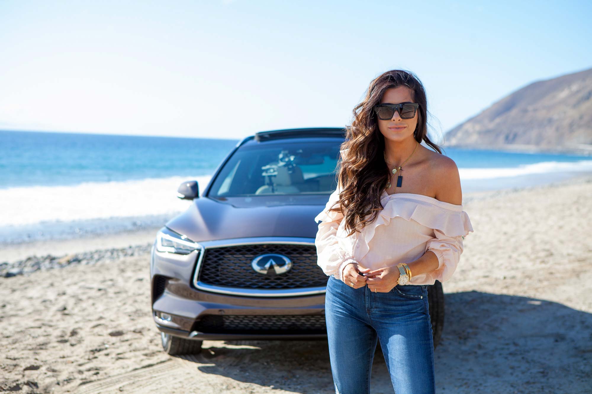 Fashion Photography of social media influencer driving and standing in front of new Infiniti QX50 car