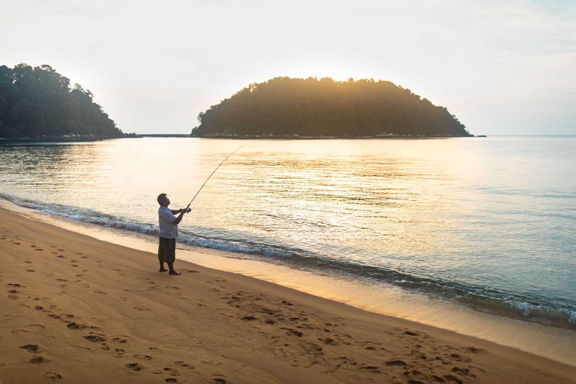 Man fishing on the beach in Pangkor Malaysia
