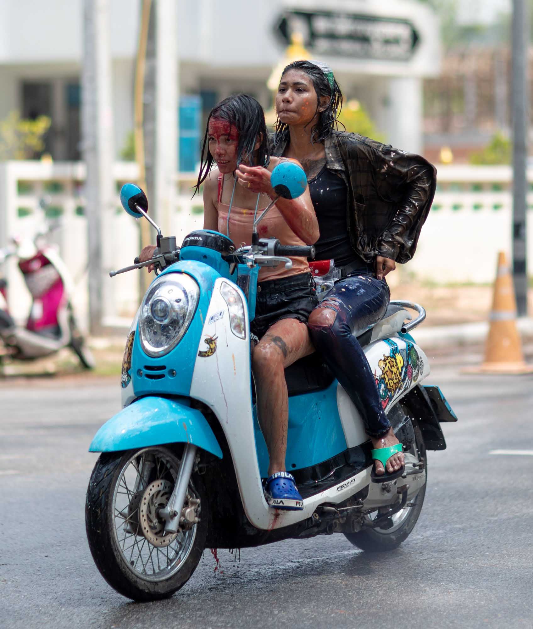 Two women with painted faces on motorcycle during Songkran water festival in Phuket, Thailand | Street Photography | Travel Photography | Festival Photography