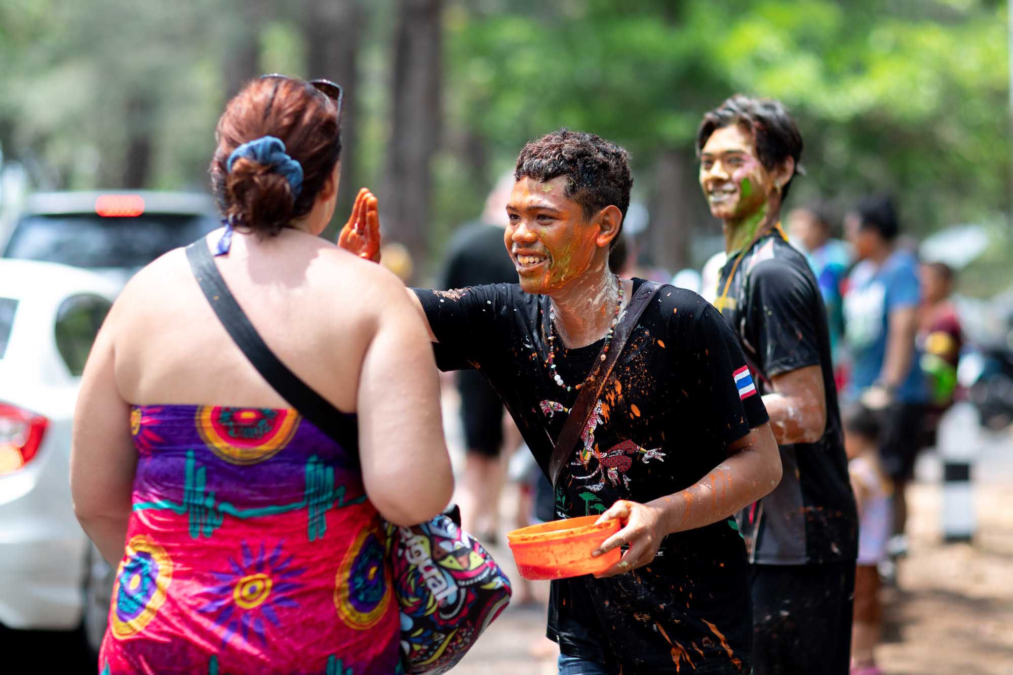 Woman gets paint put on her face during Songkran water festival in Phuket, Thailand