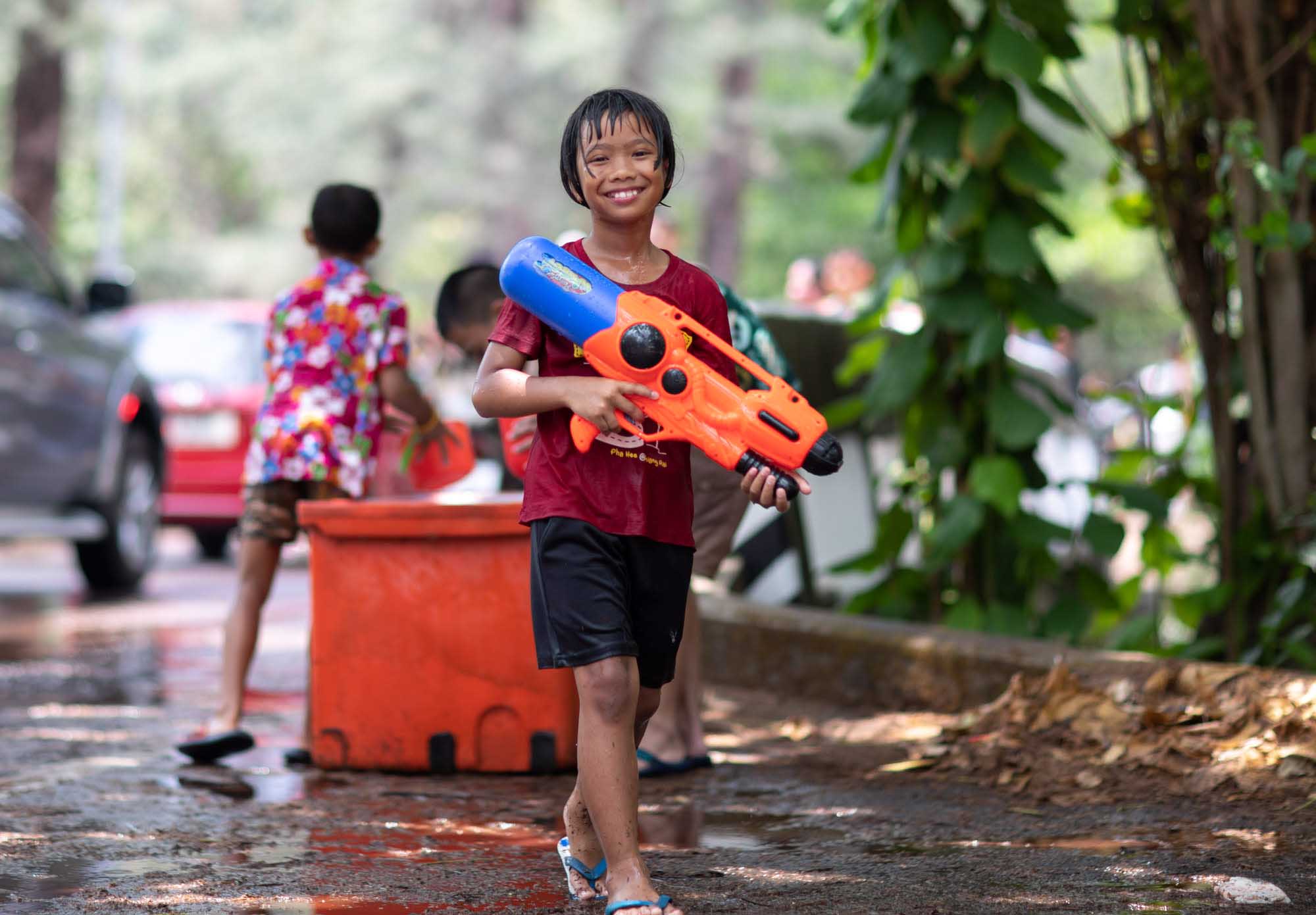 Smiling boy holds a squirt gun at Songkran water festival in Phuket, Thailand | Street Photography | Travel Photography | Festival Photography