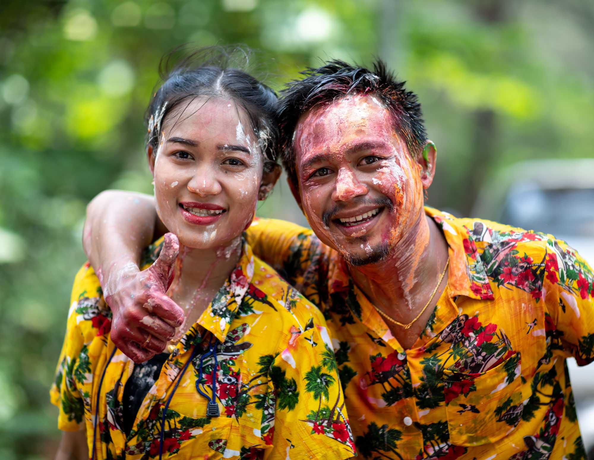 Man and woman smiling with paint on their faces at Songkran water festival in Phuket, Thailand
