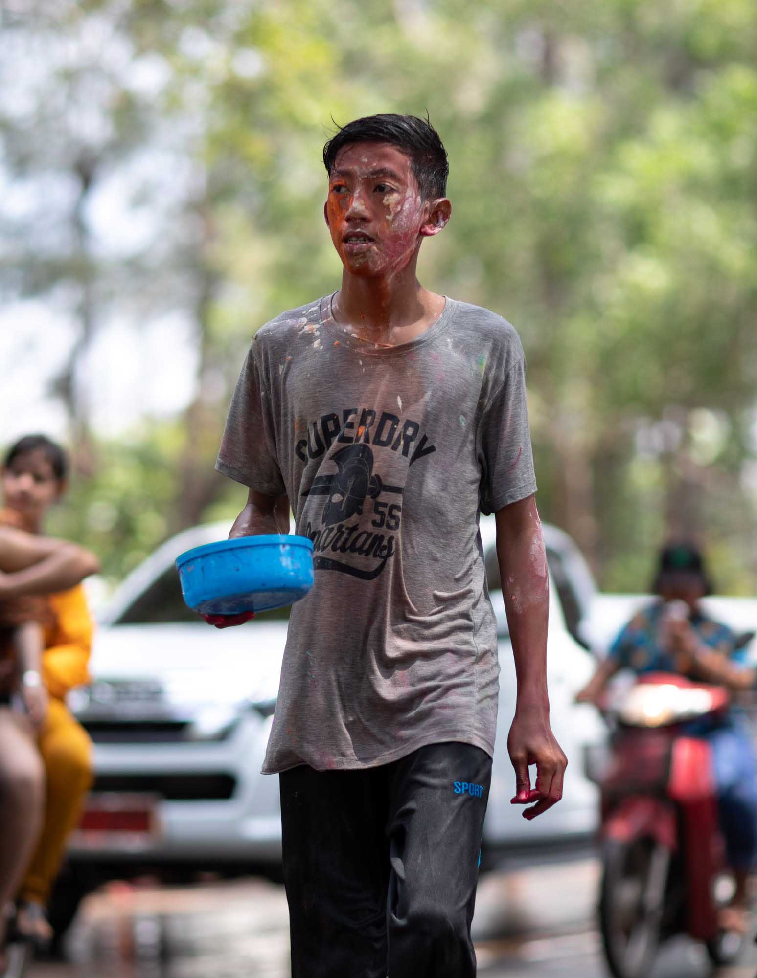 Young man with paint on his face at Songkran water festival in Phuket, Thailand