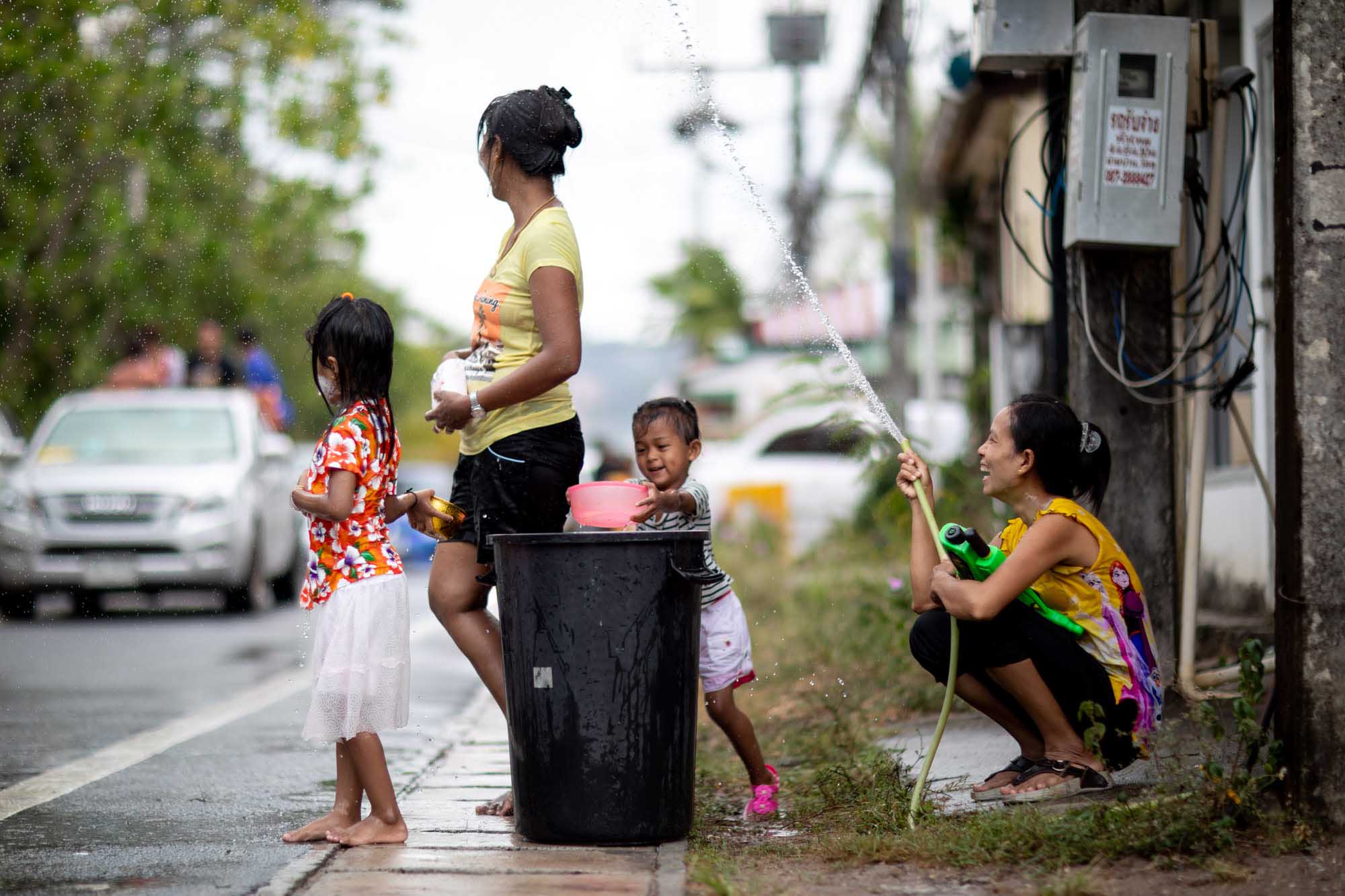 Happy family celebrates Songkran water festival in Phuket, Thailand