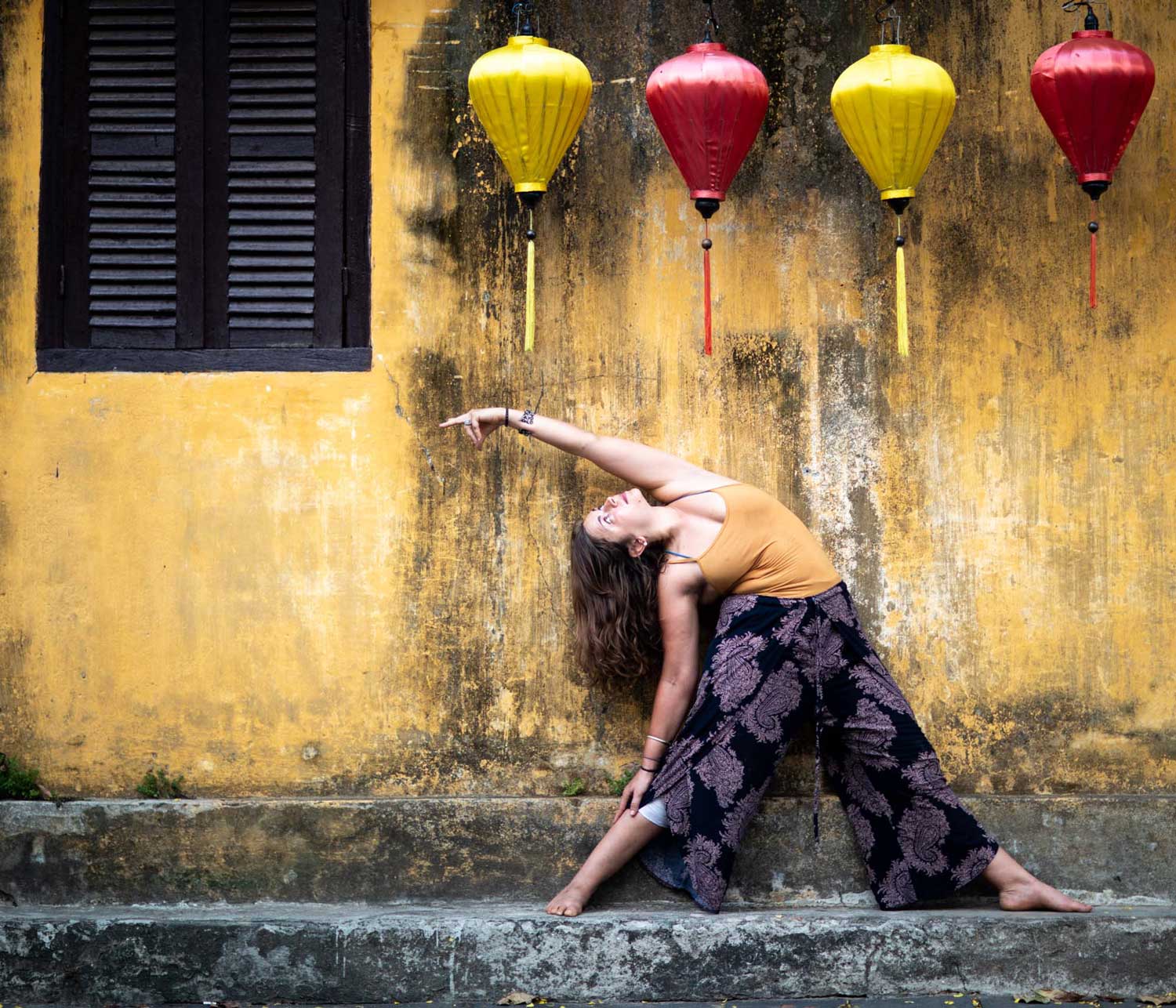 Woman does a yoga pose next to a yellow wall and lanterns | Hoi An Vietnam | Travel Photography | Yoga Photography