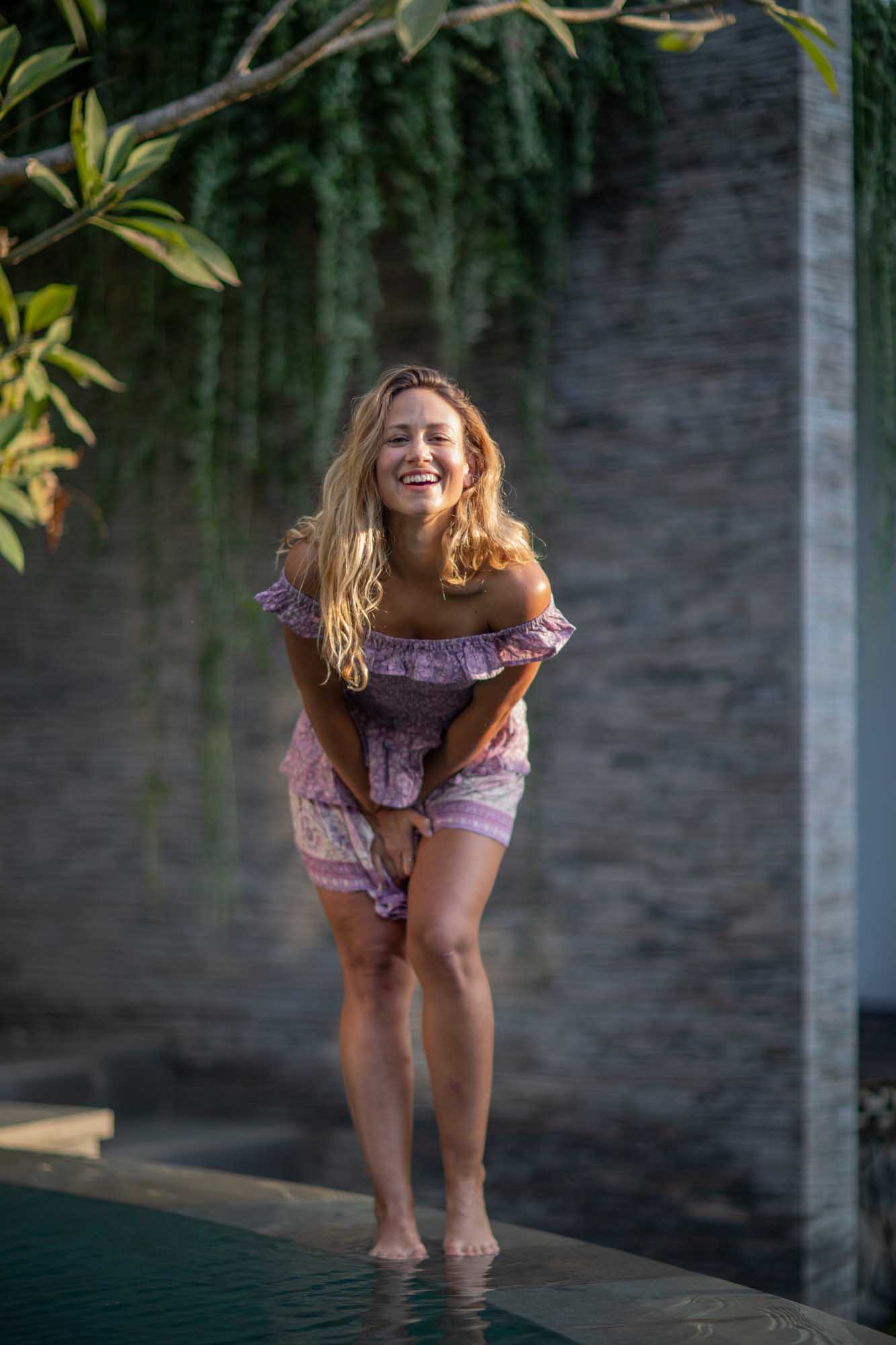 Beautiful blonde woman playfully laughs while standing on the edge of pool | Canggu Bali Indonesia | Toraja Villa | Lifestyle Photography | Fashion Photography | Travel Photography 