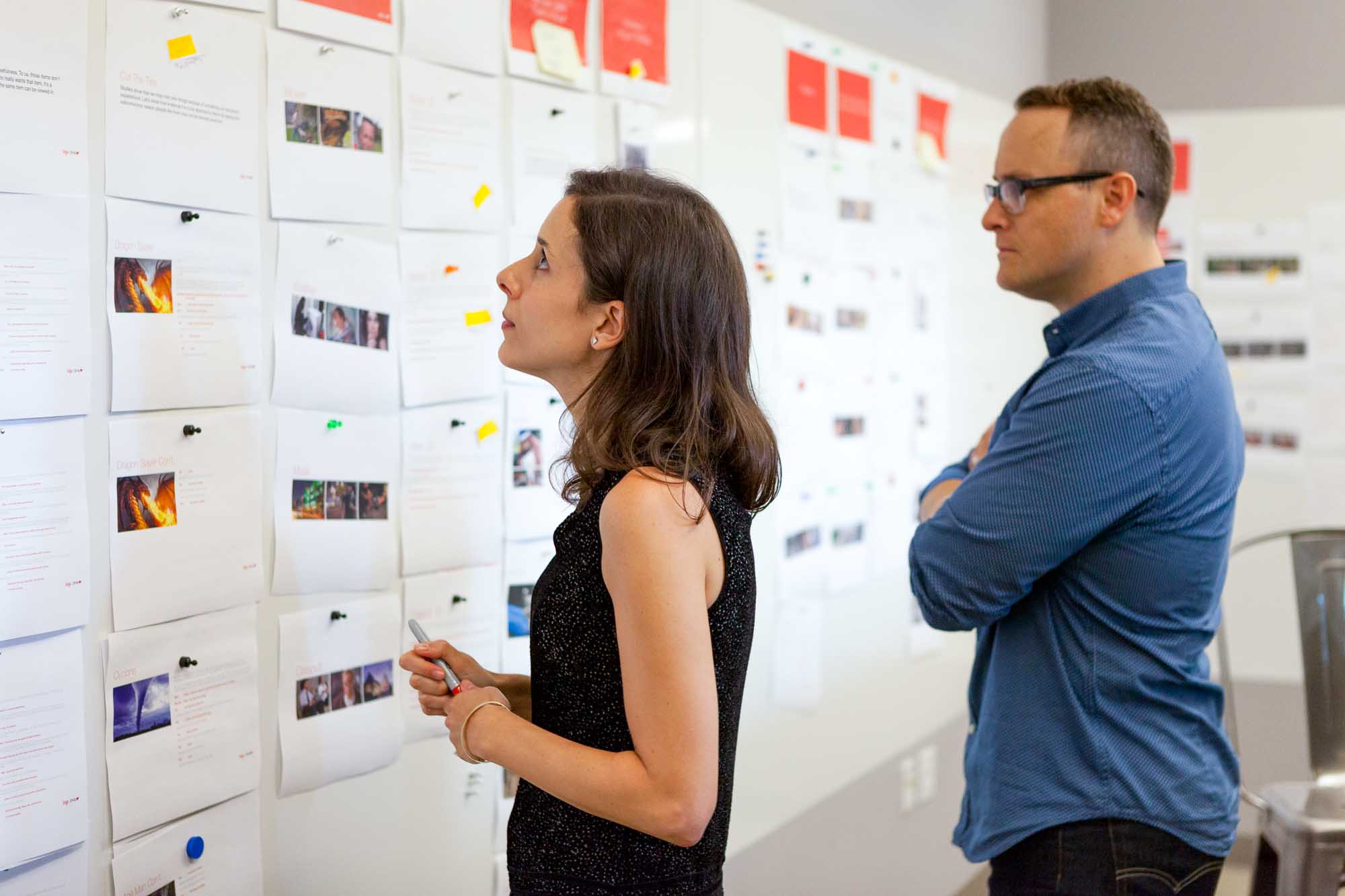 Company Executives examining creative documents on a wall. 