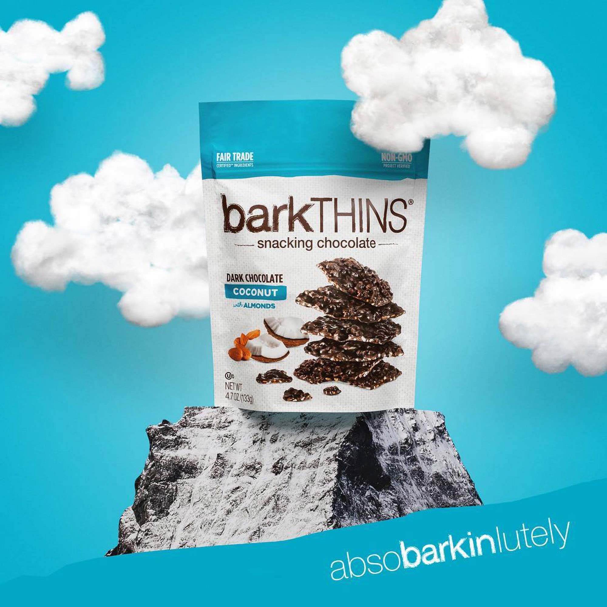 Barkthins coconut dark chocolate bag on top of mountain with cotton clouds, product photography | Still Life Photography shot in Boulder, Colorado for Crispin Porter + Bogusky