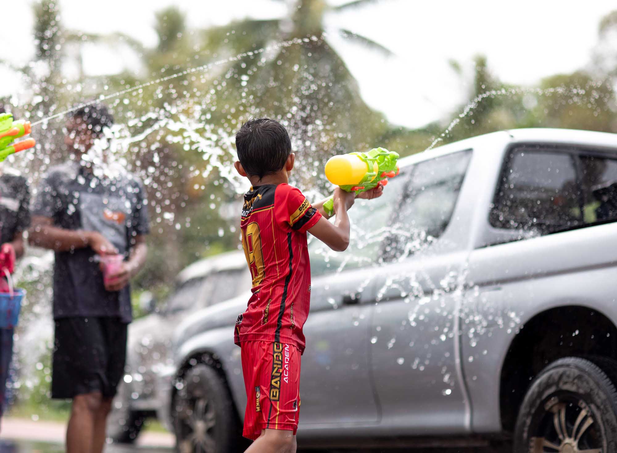 Boy shoots water gun at Songkran water festival in Phuket, Thailand | Travel Photography | Dramatic High Speed 